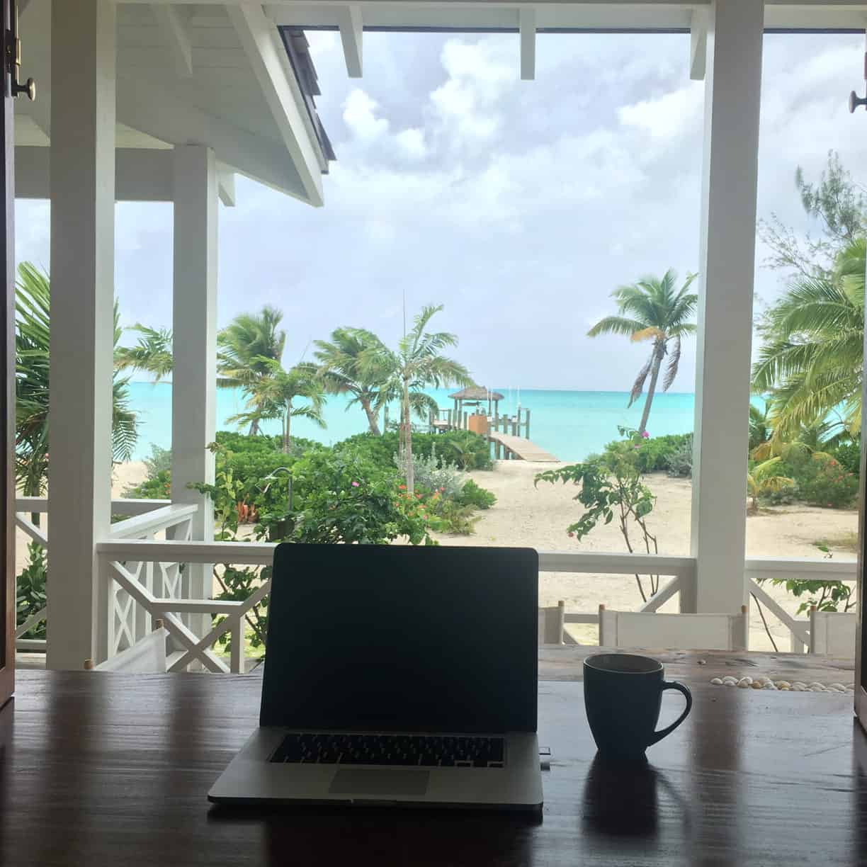 laptop coffee table tropical resort destination beach blue water