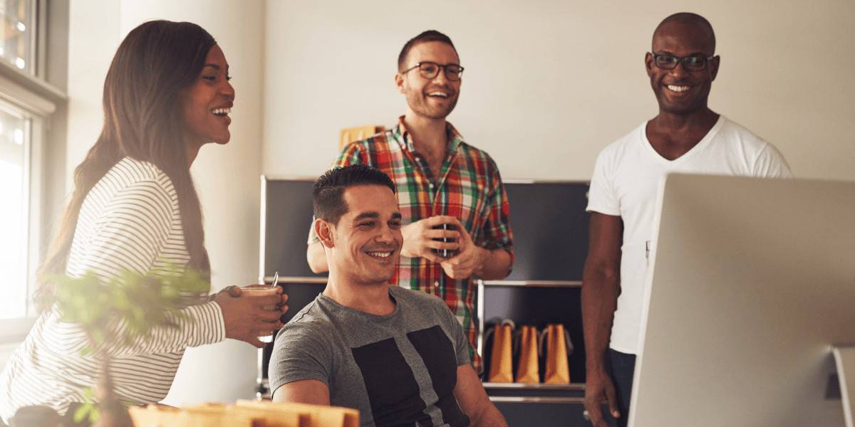 small group of marketing experts around a iMac black white hyspanic youth